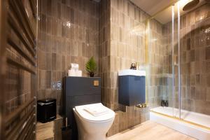 a bathroom with a toilet and a sink and a shower at Tyn-y-Coed Inn in Betws-y-coed +95 photos