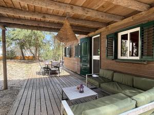 a wooden deck with a couch and a table at Casa Silvestre in Melides