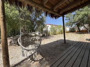 a swinging chair on a porch with a roof at Casa Silvestre in Melides
