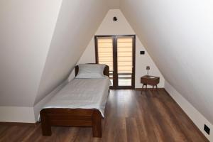 a attic bedroom with a bed and a window at Kiki house in Čačak