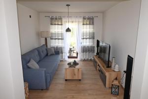 a living room with a blue couch and a tv at Kiki house in Čačak