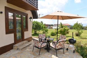 a patio with a table and two chairs and an umbrella at Kiki house in Čačak