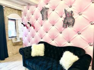 a black couch in a room with a pink wall at Caporizon-Lov'BNB-La seule Love House de Dordogne in Biras +27 photos