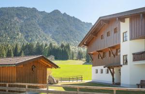 a building with a field and mountains in the background at Jägers Highlineblick in Breitenwang +28 photos