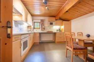a kitchen with a table and a wooden ceiling at Jägers Highlineblick in Breitenwang