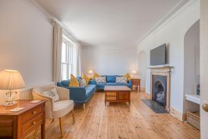 a living room with a blue couch and a fireplace at Ty Mor in Tenby