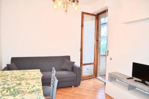 a living room with a couch and a television at Vicolo della Chiusa in Rosia