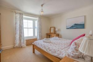 a bedroom with a bed and a window at Ty Mor in Tenby