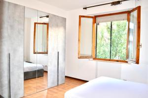a bedroom with a mirror and a window at Vicolo della Chiusa in Rosia