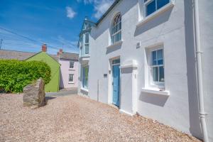 a white house with a blue door at Ty Mor in Tenby