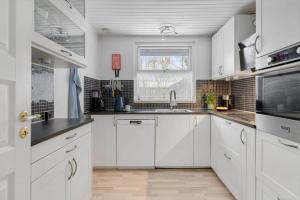 a white kitchen with white cabinets and a window at 1670-Melby-Kragesvej-36 in Melby