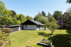 a small house in a yard with a tree at 1670-Melby-Kragesvej-36 in Melby