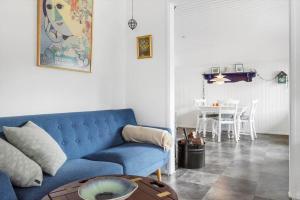 a living room with a blue couch and a table at 8881-Glesborg-Benzonstien-27 in Fjellerup Strand +18 photos