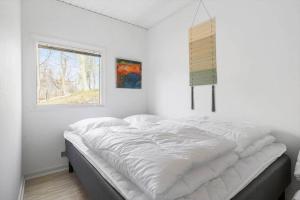 a bed in a room with a window at 8881-Glesborg-Benzonstien-27 in Fjellerup Strand