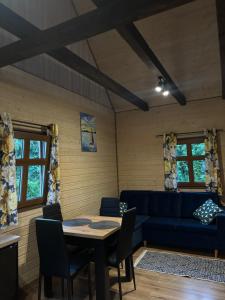 a living room with a blue couch and a table at Domki Stokrotka in Ruciane-Nida