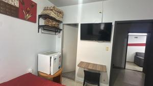 a room with a bed and a tv on a wall at Hotel Ype de São Carlos in São Carlos