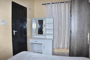 a bedroom with a white dresser and a mirror at Maya Haven in Ukunda