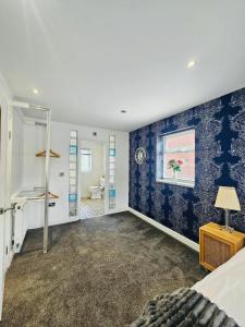 a bedroom with blue and white walls and a window at Luxury Home with Pool in Barnsley