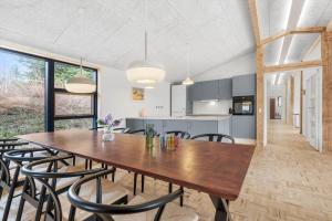 a kitchen and dining room with a wooden table and chairs at 8882-Glesborg-Kaervejen-5 in Fjellerup Strand