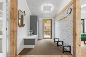 a hallway with a bathroom with a clock on the wall at 8882-Glesborg-Kaervejen-5 in Fjellerup Strand +18 photos