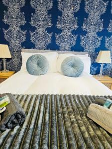 a bedroom with a white bed with blue wallpaper at Luxury Home with Pool in Barnsley