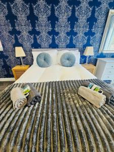 a bedroom with a large bed with blue wallpaper at Luxury Home with Pool in Barnsley