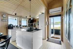 a kitchen with white cabinets and a view of the ocean at 84256-Ronde-Strandvejen-108 in Rønde
