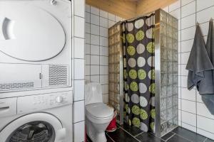 a bathroom with a washing machine and a toilet at 84256-Ronde-Strandvejen-108 in Rønde