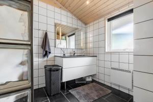 a bathroom with a sink and a mirror at 84256-Ronde-Strandvejen-108 in Rønde +19 photos