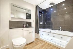 a bathroom with a tub and a toilet and a sink at The Stables in Great Horkesley