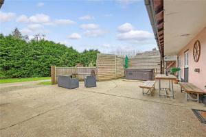 a patio with tables and chairs and a fence at The Stables in Great Horkesley
