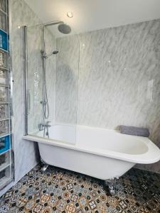 a bath tub with a glass shower in a bathroom at Luxury Home with Pool in Barnsley +25 photos