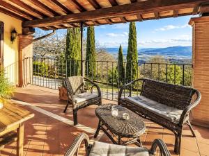 a patio with a couch and chairs on a balcony at Villa Le More by Interhome in Penna in Teverina