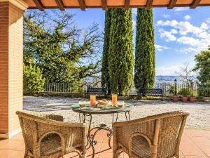 a patio with a table and chairs and trees at Villa Le More by Interhome in Penna in Teverina