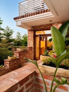 a brick house with a front porch with plants at Artelier Vama Veche in Vama Veche
