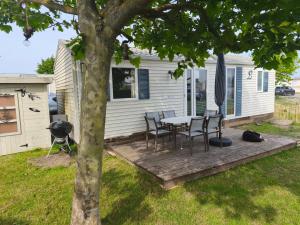 a table and chairs on a deck next to a house at Bredene Haus Schildkröte in Bredene +12 photos