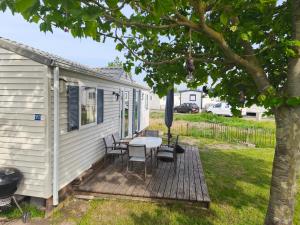 a deck with a table and chairs on a house at Bredene Haus Schildkröte in Bredene