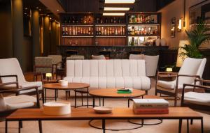 a living room with a couch and tables and chairs at Honest Budapest by chic&basic in Budapest