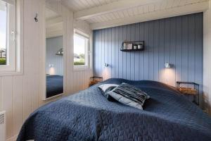 a bedroom with a blue bed and a mirror at C11638-Hemmet-Vester-Faelled-49 in Hemmet