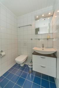 a white bathroom with a sink and a toilet at Rorbuene Svolvær Havn in Svolvær