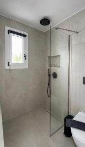 a shower with a glass door in a bathroom at Ammos Maisonettes in Pefkari