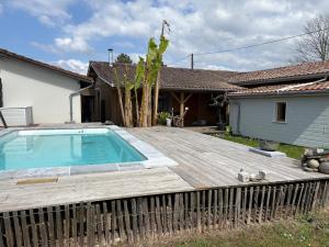 a backyard with a wooden deck and a swimming pool at Villa Serena offrez vous une parenthese in Le Porge