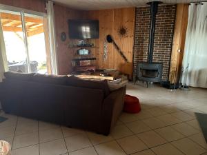 a living room with a couch and a fireplace at Villa Serena offrez vous une parenthese in Le Porge