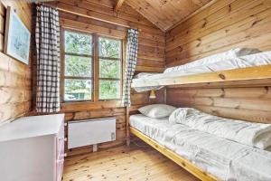 a room with two bunk beds in a wooden cabin at 84249-Knebel-Skraningen-13 in Knebel