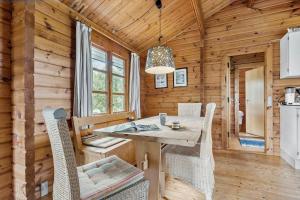 a dining room with a table and chairs in a log cabin at 84249-Knebel-Skraningen-13 in Knebel