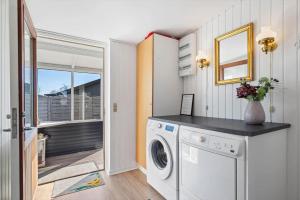 a laundry room with a washing machine and a window at 8501-Grenaa-Ellevej-14 in Grenå Strand