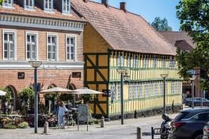 a woman standing in front of a yellow building at 8501-Grenaa-Ellevej-14 in Grenå Strand