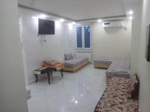 a room with beds and a tv on the wall at La perle de Sétif in Sétif