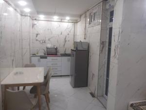 a small kitchen with a table and a refrigerator at La perle de Sétif in Sétif