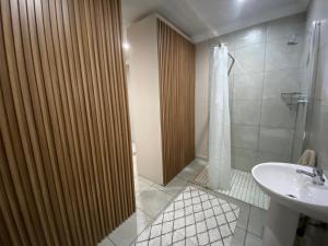 a bathroom with a shower and a sink at Slaapnet Guesthouse Long Stay Accommodation Wilkoppies in Klerksdorp +98 photos